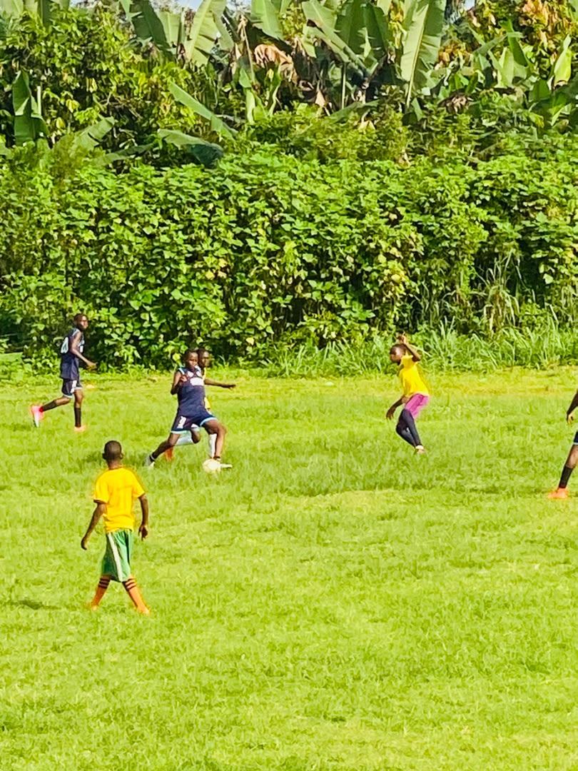 Academy players in navy kit competing during a match